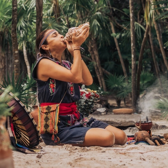 Native,Woman,In,Traditional,Clothes,Playing,Music,With,White,Shell